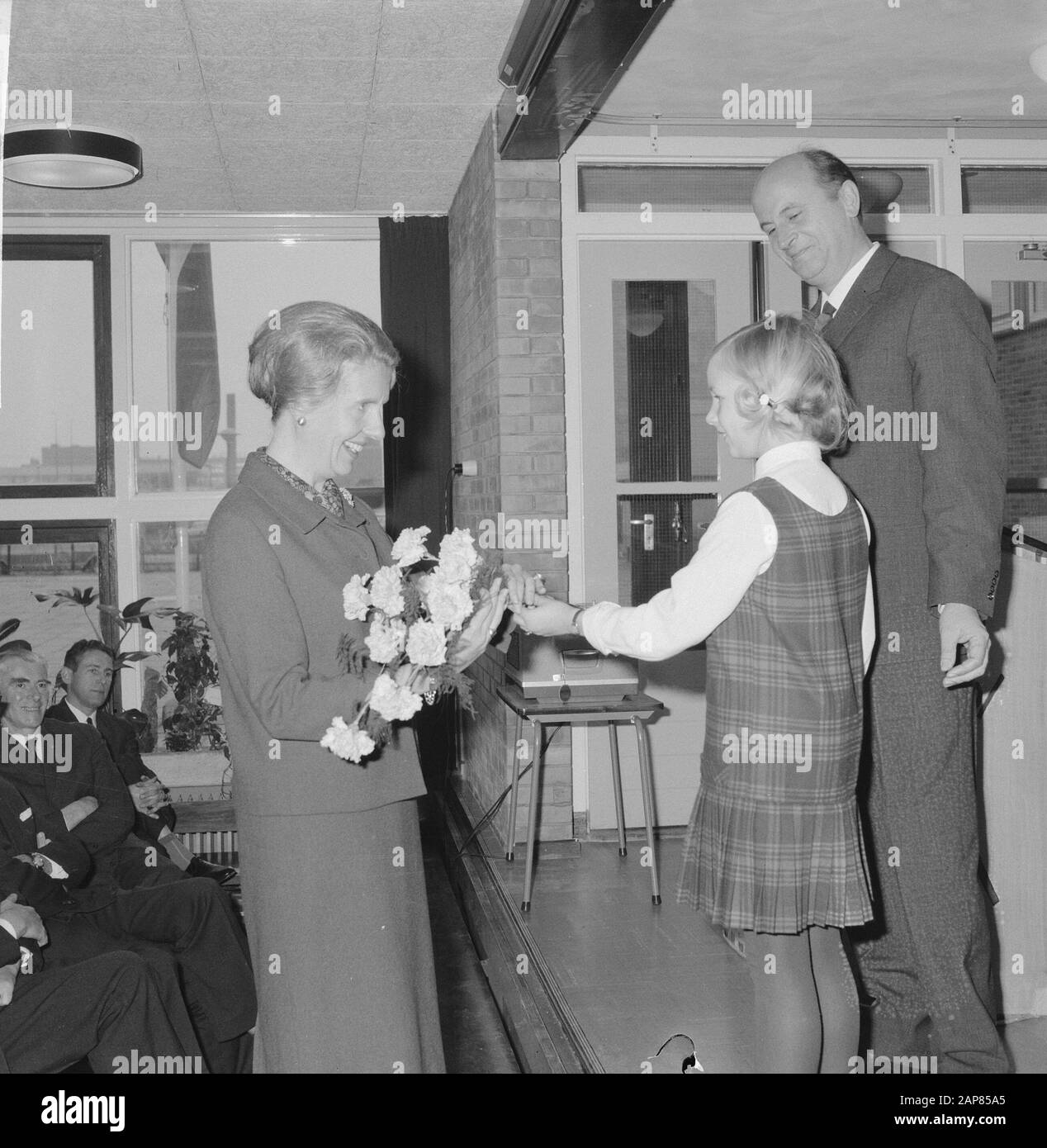 Il Sindaco Van Hall aprì una scuola per bambini non udenti ad Amsterdam; l'allievo consegna un bouquet a una signora (presumibilmente la signora Van Hall) Data: 16 dicembre 1965 Località: Amsterdam, Noord-Holland Parole Chiave: Fiori, bambini, aperture Foto Stock