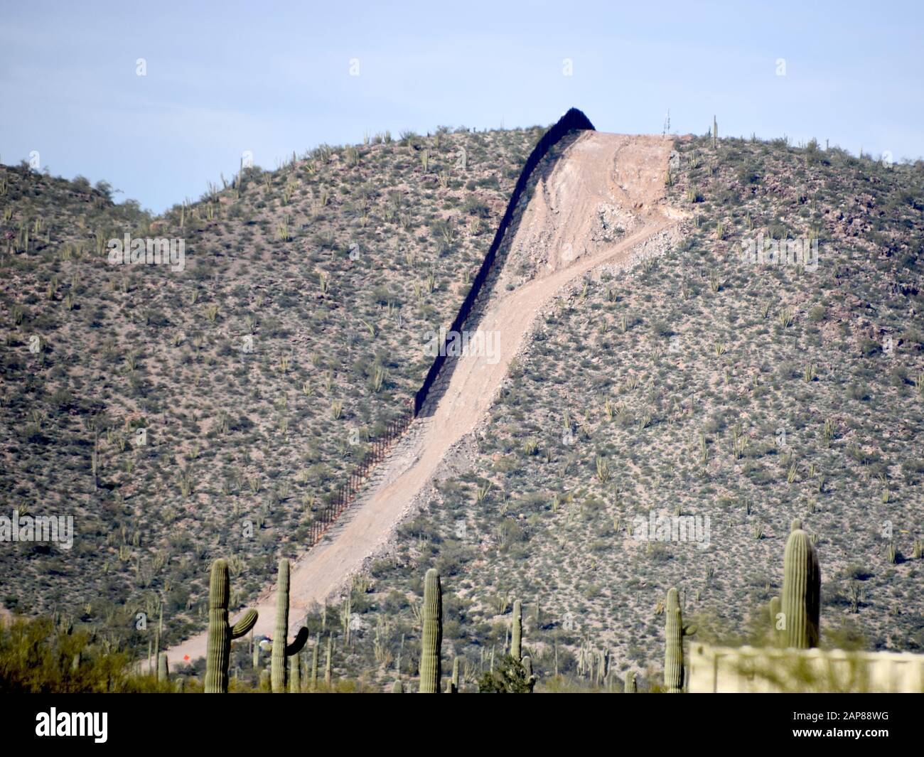 La vecchia barriera di confine dilatata può essere vista lungo il confine degli Stati Uniti e del Messico in cima alla Monument Mountain prima di essere sostituita con un sistema di strutto aggiornato, Ajo, Arizona, 20 gennaio 2020. Questo progetto è stato eseguito dal corpo degli ingegneri dell'esercito degli Stati Uniti, come diretto attraverso l'esercito degli Stati Uniti dal Segretario della Difesa, In risposta alla richiesta di assistenza del Dipartimento di sicurezza interna per contribuire a garantire la frontiera meridionale degli Stati Uniti bloccando i corridoi per il traffico di droga attraverso la costruzione di strade e recinzioni, e l’installazione dell’illuminazione ai sensi del titolo 10, sezione 284 della Foto Stock