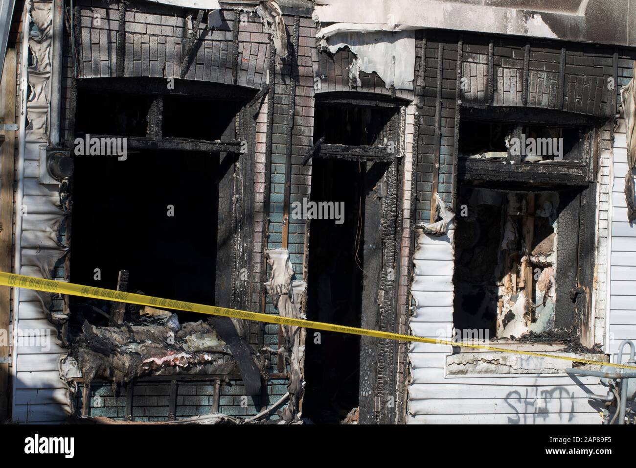 Arson investigation casa fuoco primo piano con nastro giallo crimine. Struttura incendio edificio danneggiato da incendio. Incendio reparto indagini casa distrutto Foto Stock