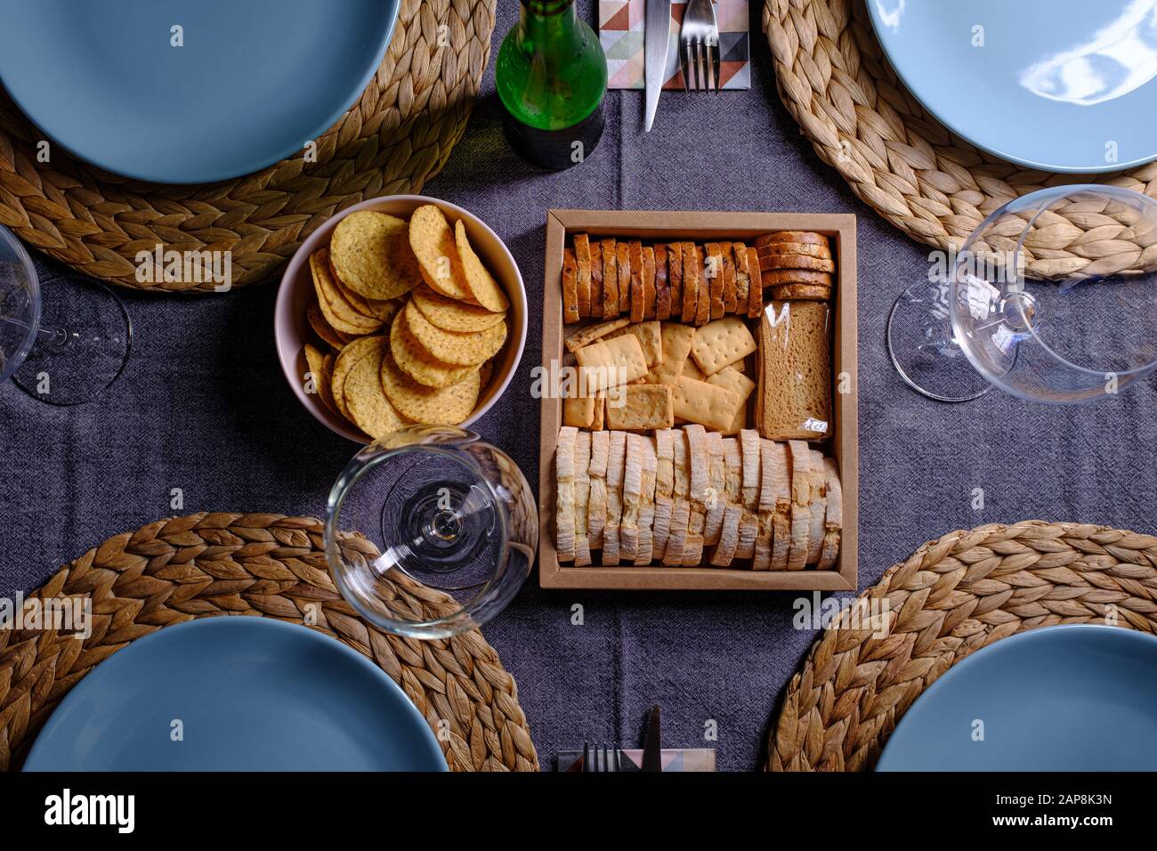 Diverse fette di pane tostato su una scatola di legno su un tavolo da pranzo ristorante preparato in blu e grigio Foto Stock