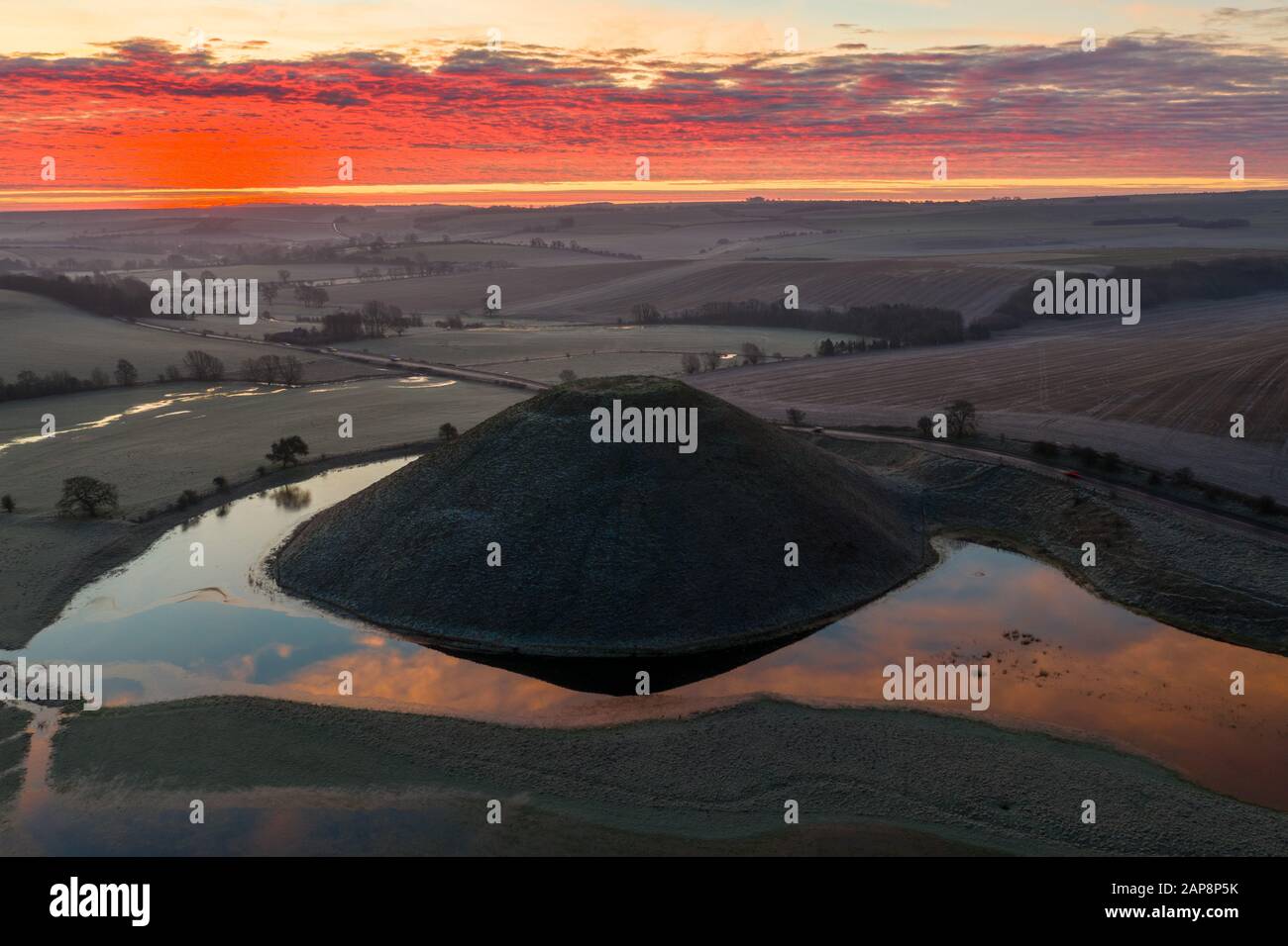 Silbury Hill, Nr Avebury, Wiltshire, Regno Unito. 20th gennaio 2020. Immagini dei droni di una spettacolare alba gelida rossa e l'antico tumulo artificiale di Silbury Foto Stock