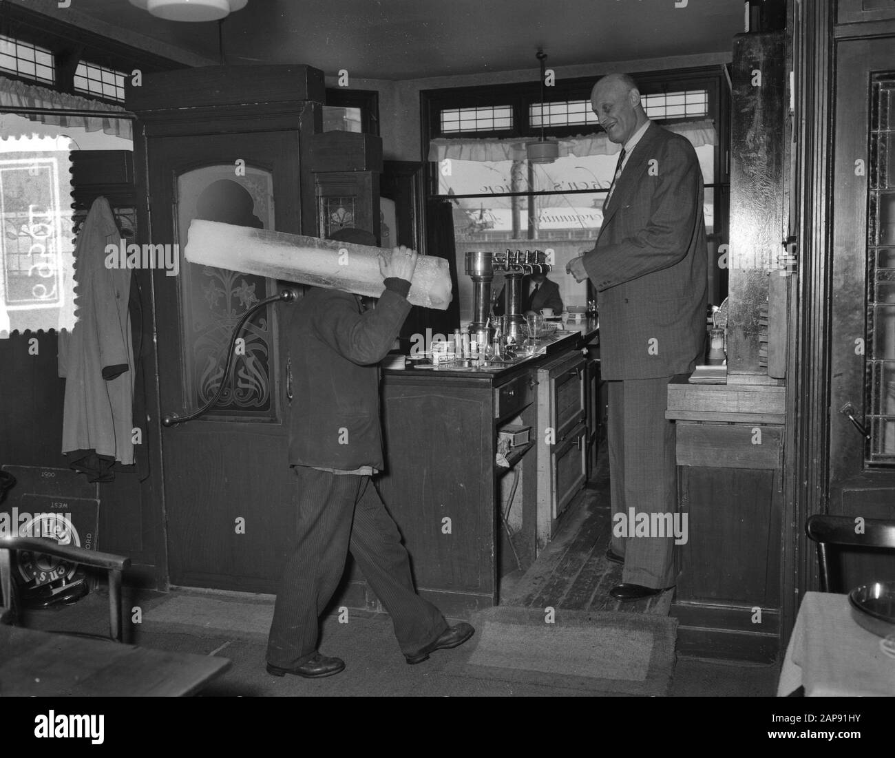 Albert J. Kramer, il più grande uomo del mondo (2,42 m) nella sua caffetteria all'angolo della Sloterkade e Theophile de Bockstraat ad Amsterdam Data: 20 gennaio 1955 posizione: Amsterdam, Noord-Holland Parole Chiave: Caffè, catering, altezza, uomini Nome personale: Kramer, A.J. Foto Stock