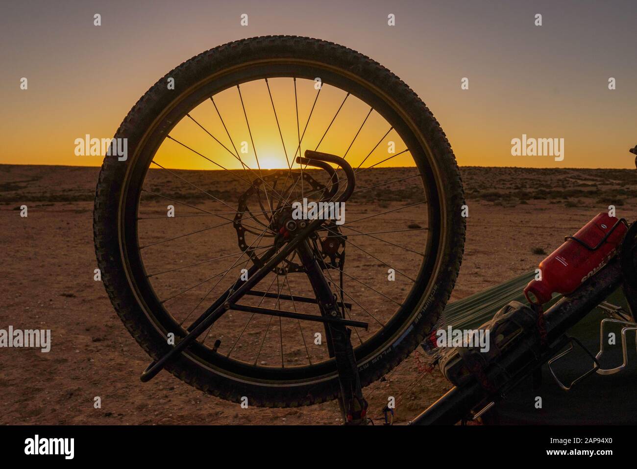 alba nel deserto nel sud del marocco. sul davanti c'è la ruota di una bici da turismo Foto Stock