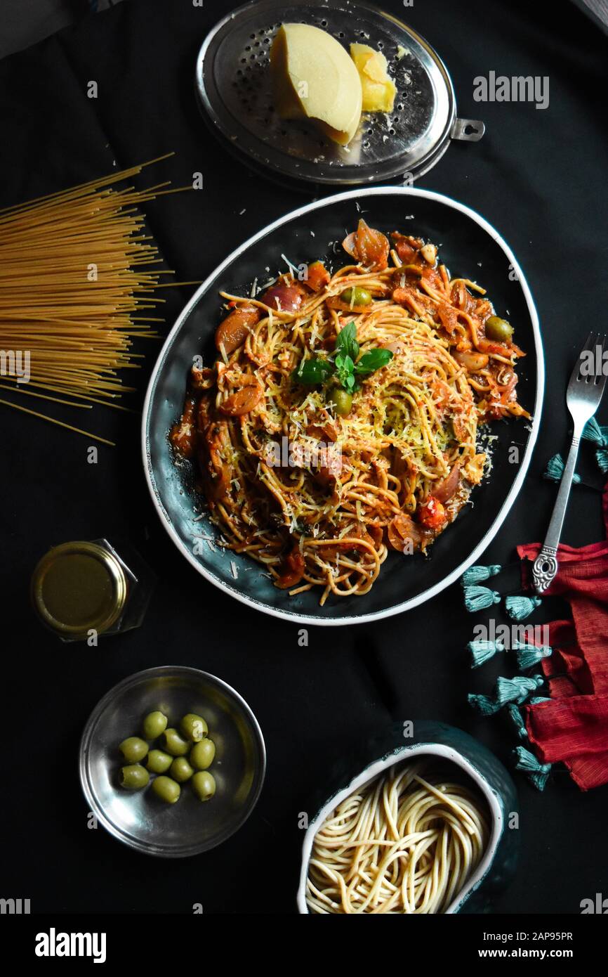 Spaghetti italiani classici ragù alla bolognese in un piatto nero, spaghetti alla bolognese con vista dall'alto e ingredienti per cucinare pasta e pasta Foto Stock