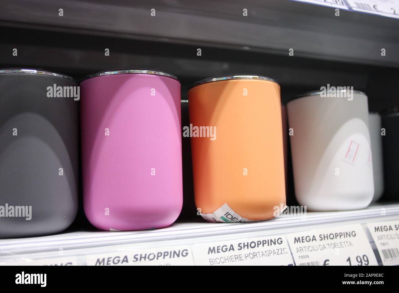bicchieri colorati o contenitori di vari articoli domestici per qualsiasi uso domestico collocati su un ripiano in un negozio o scaffale in casa in italia Foto Stock