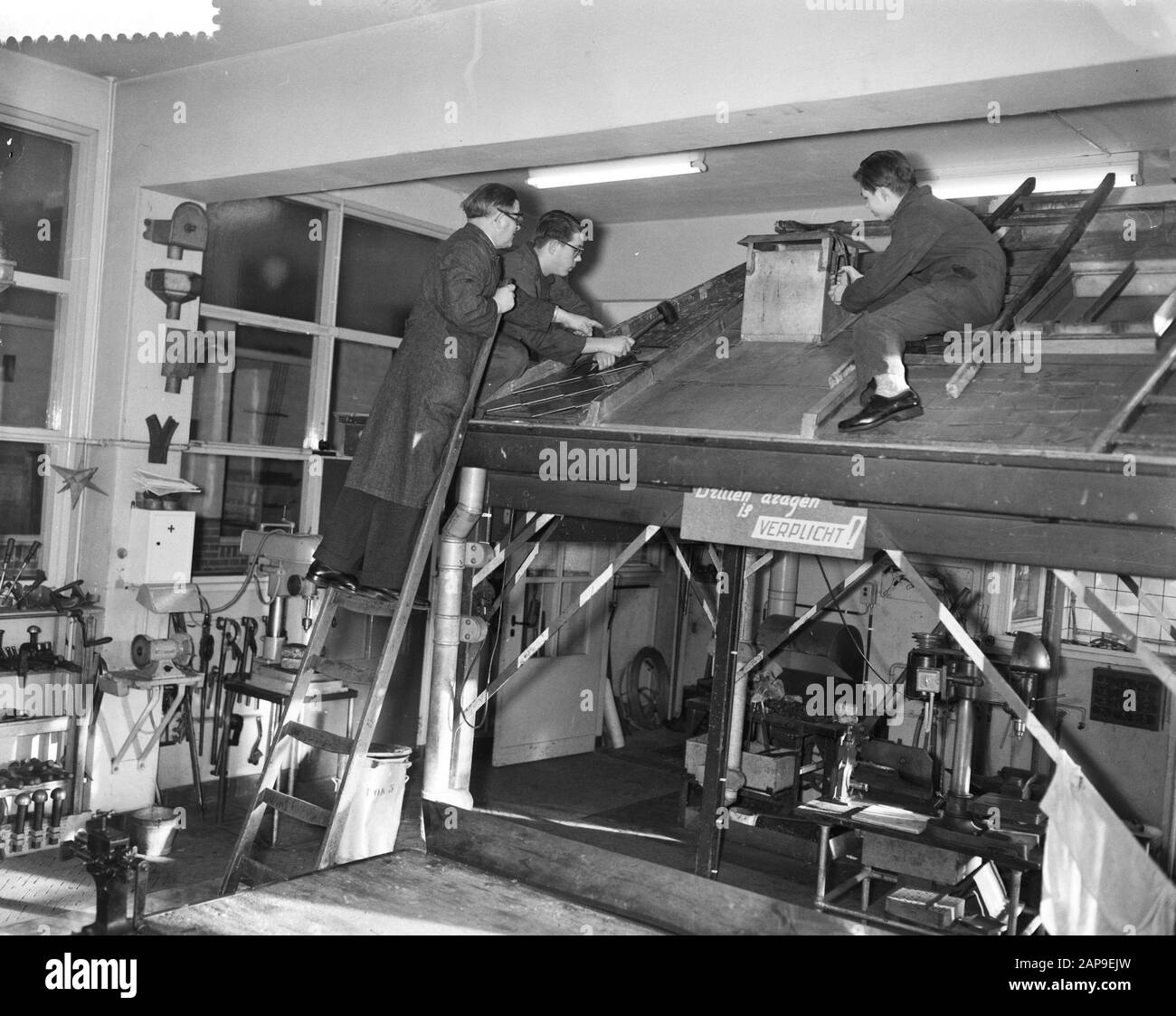 100 anni di educazione tecnica ad Amsterdam, pupilla su un tetto lavorando in aula Data: 11 gennaio 1961 Località: Amsterdam, Noord-Holland Parole Chiave: PLOUDGIERS, TETTI DIDATTICI, allievi Foto Stock
