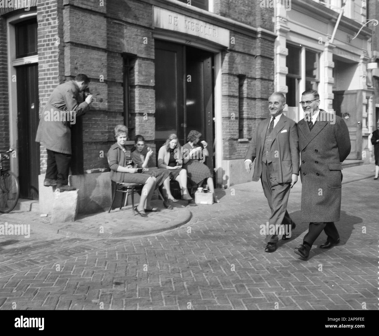 Visita L'Ambasciatore Britannico Sir And Lady Noble Ad Amsterdam. Passeggiata attraverso la città. Sinistra Sir Andrew Noble, sindaco destra Van Hall Annotazione: Camminano oltre l'edificio con nella pietra di fronte il nome De Mercuur. Sulla sinistra, un uomo in una giacca di tessuto film o fotografie quattro donne fuori affondo (lavoratori?) Data: 7 marzo 1961 luogo: Amsterdam, Noord-Holland Parole Chiave: Visite, sindaci, diplomatici Nome personale: Hall, G. van, Noble, Andrew Foto Stock