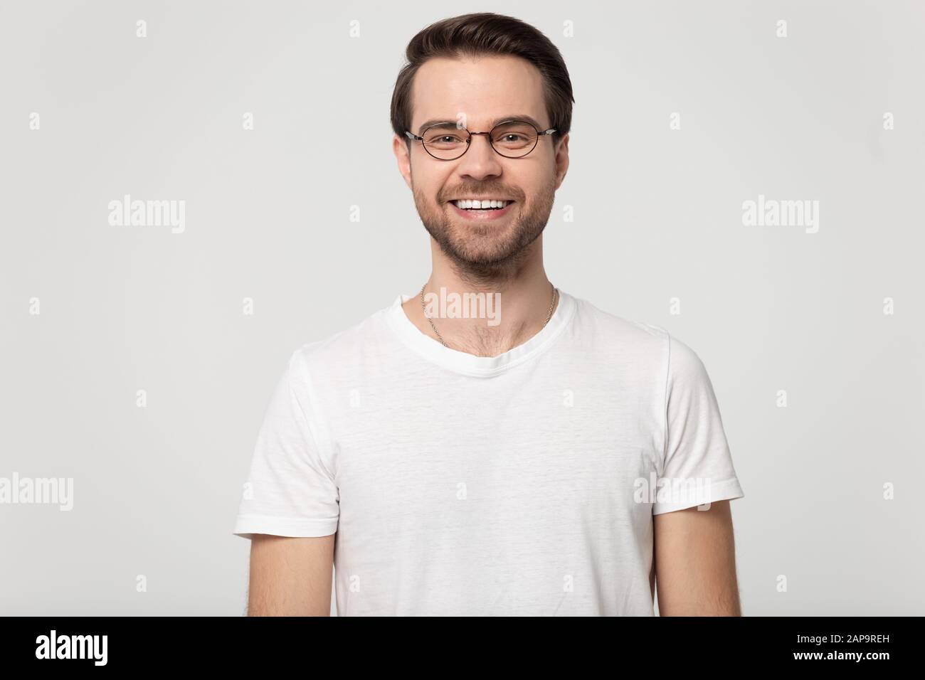 Felice sorridente ragazzo millennial indossando occhiali testa shot studio ritratto. Foto Stock