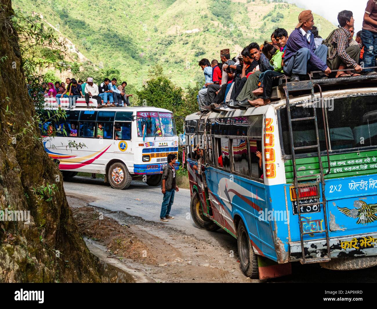 Molti passeggeri che viaggiano sul tetto di autobus sovraccaricati Foto Stock