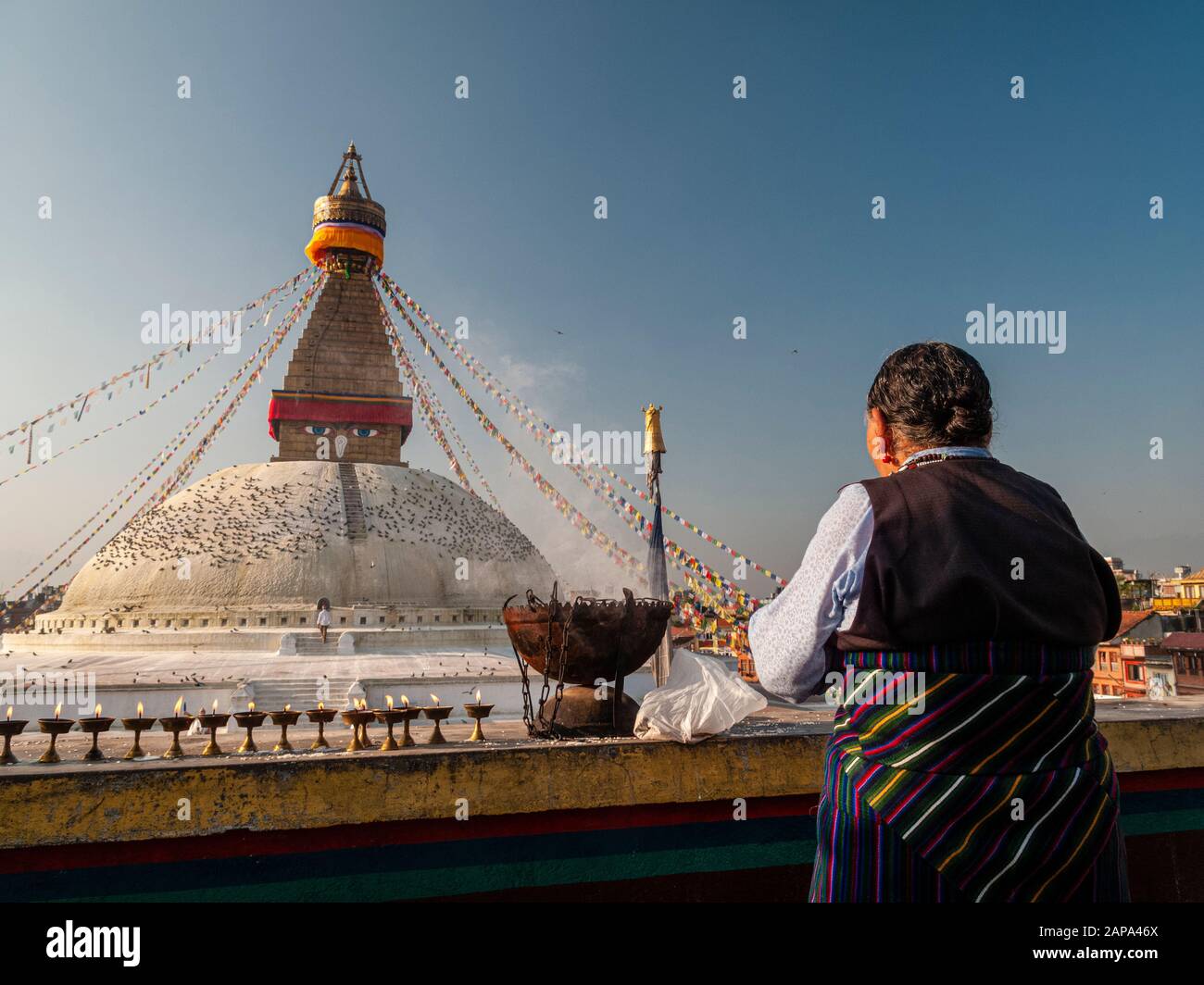 Una vecchia donna sta svolgendo una cerimonia religiosa a Boudha Stupa Foto Stock