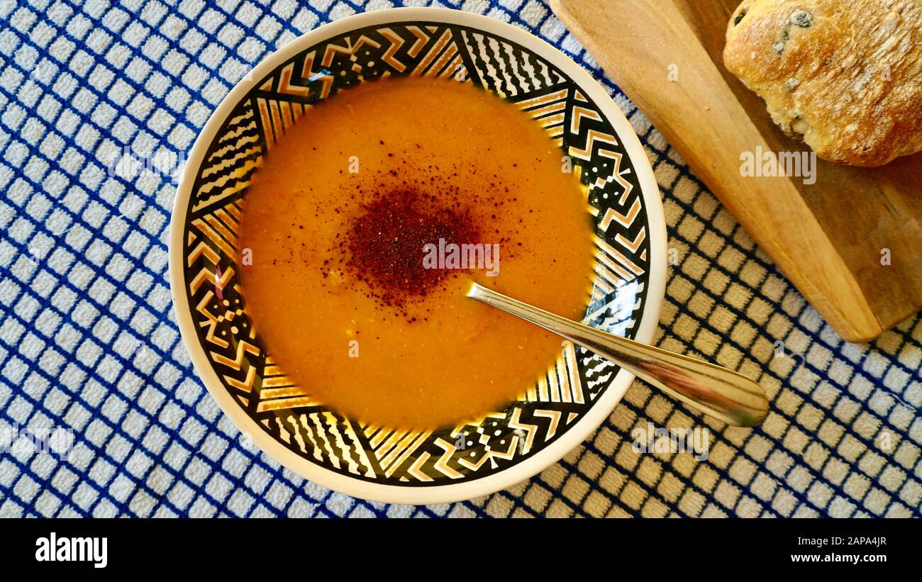 Una ciotola di zuppa vegana composta da patate dolci, zucca butternut, carote, lenticchie e peperoncino Foto Stock