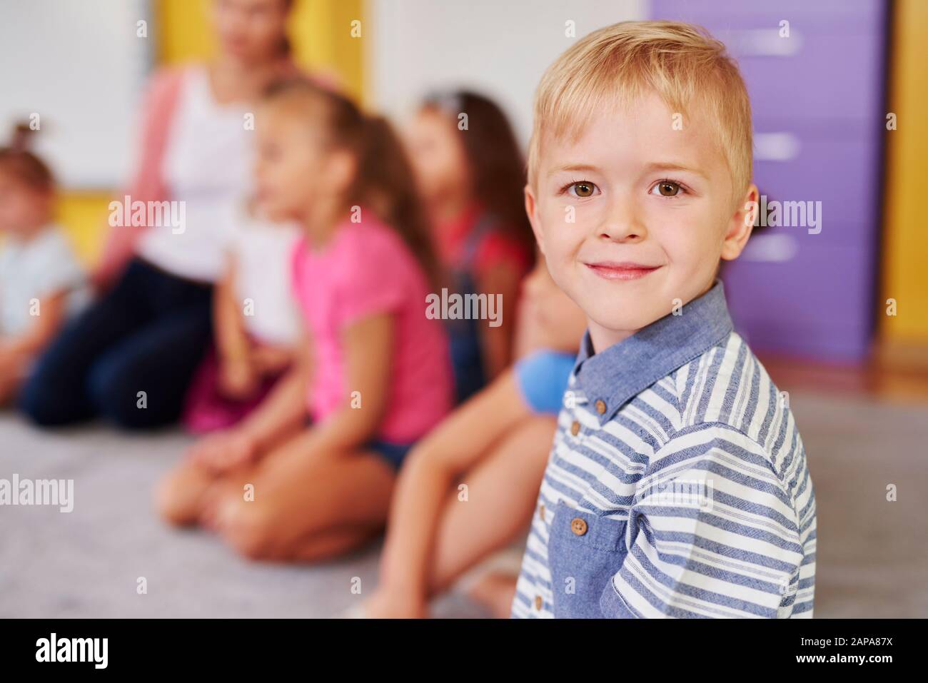 Ragazzo sorridente nella scuola materna Foto Stock