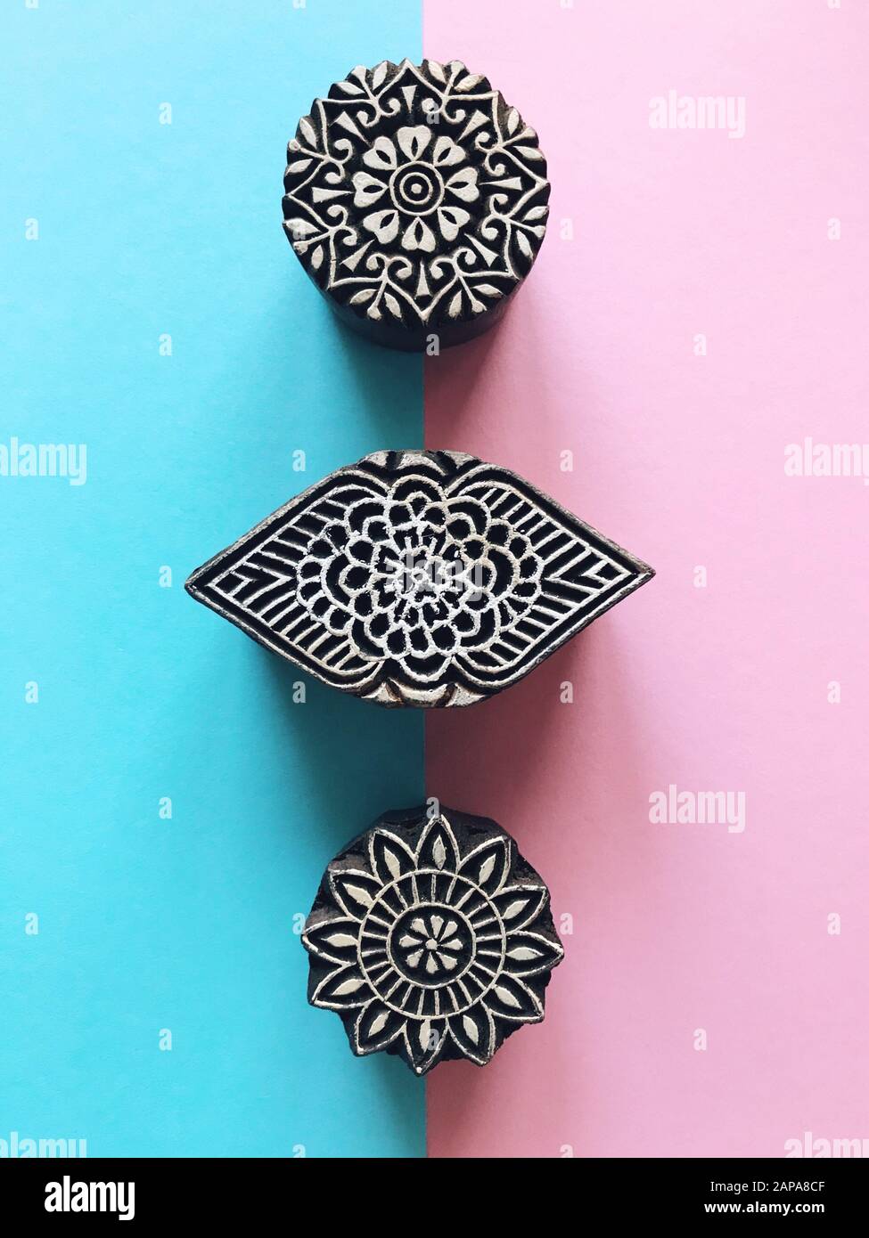 Creative Flat Lay kalamkari francobolli in legno su sfondo color pastello. Carta di colore pastello blu e rosa sfondo geometrico piatto con kalam indiano Foto Stock