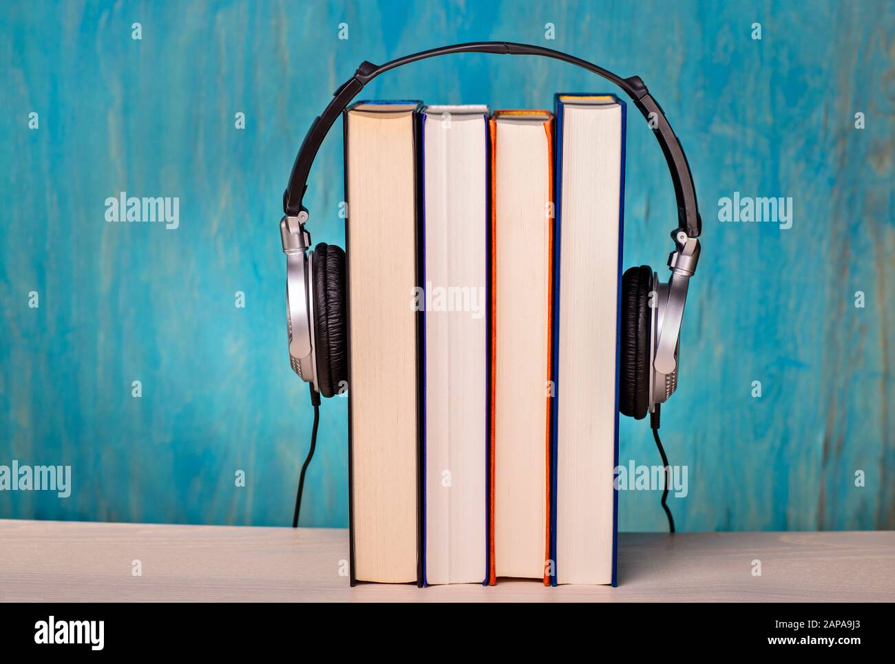 Cuffie con quattro libri come simbolo per i libri audio Foto Stock