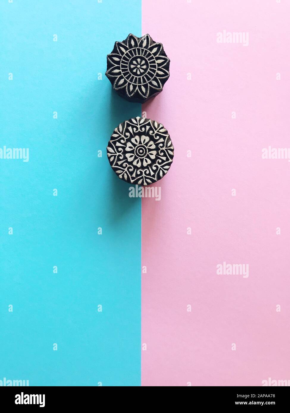 Creative Flat Lay kalamkari francobolli in legno su sfondo color pastello. Carta di colore pastello blu e rosa sfondo geometrico piatto con kalam indiano Foto Stock