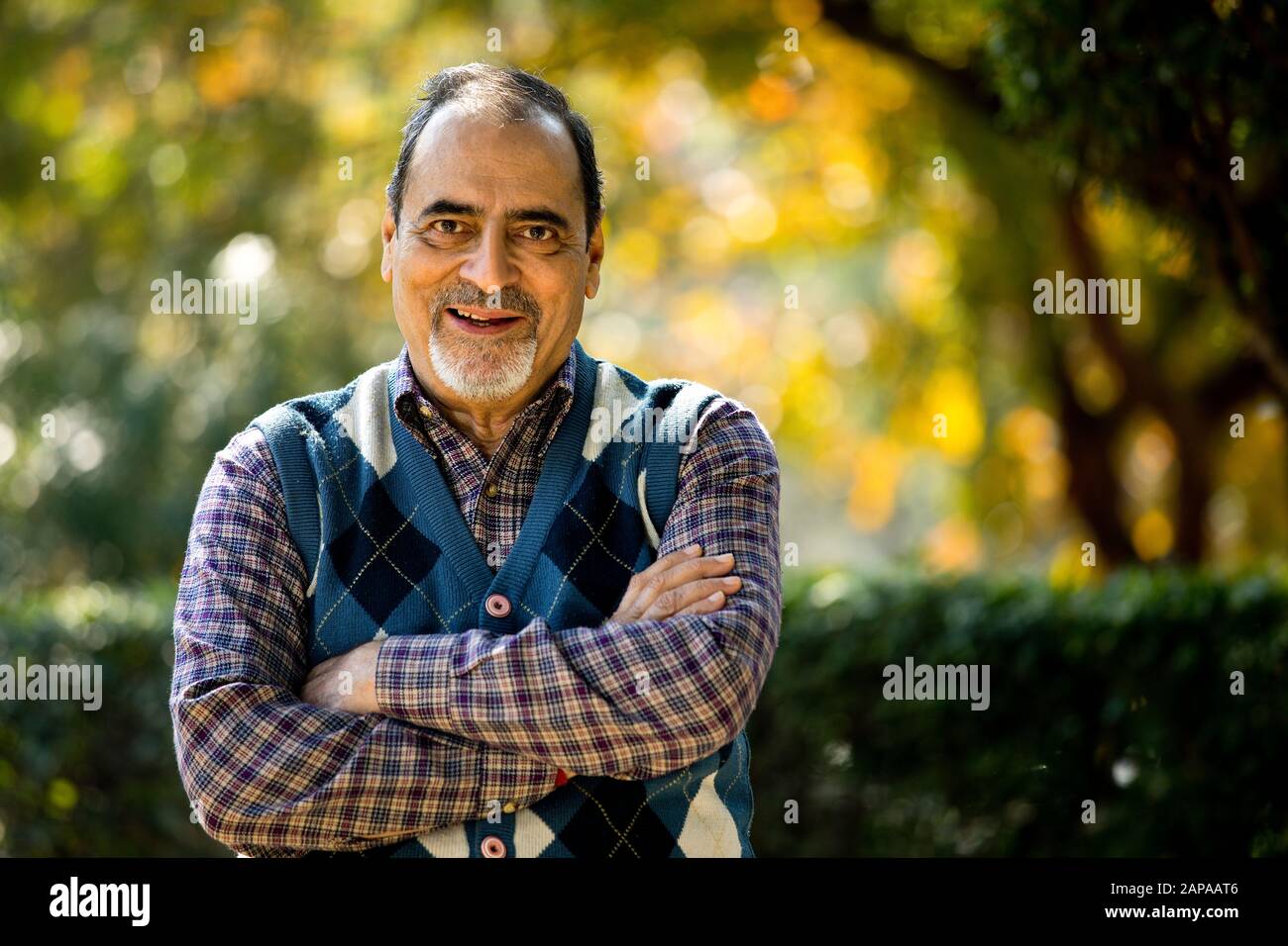 Uomo anziano sicuro con le armi incrociate al parco Foto Stock