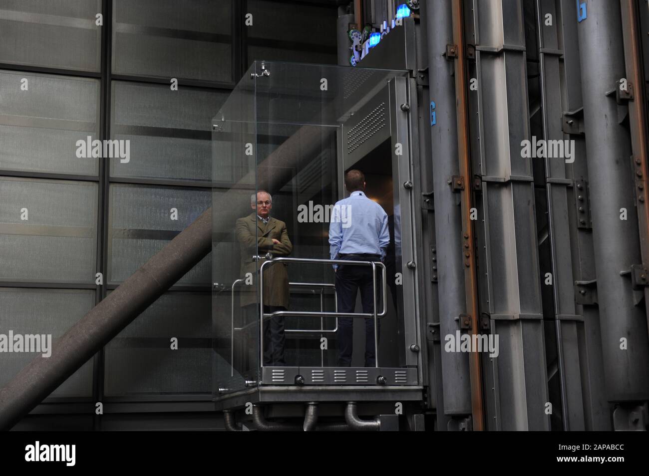La gente viaggia negli ascensori presso il Lloyd's di Londra, in Lime Street, Londra, Inghilterra Foto Stock