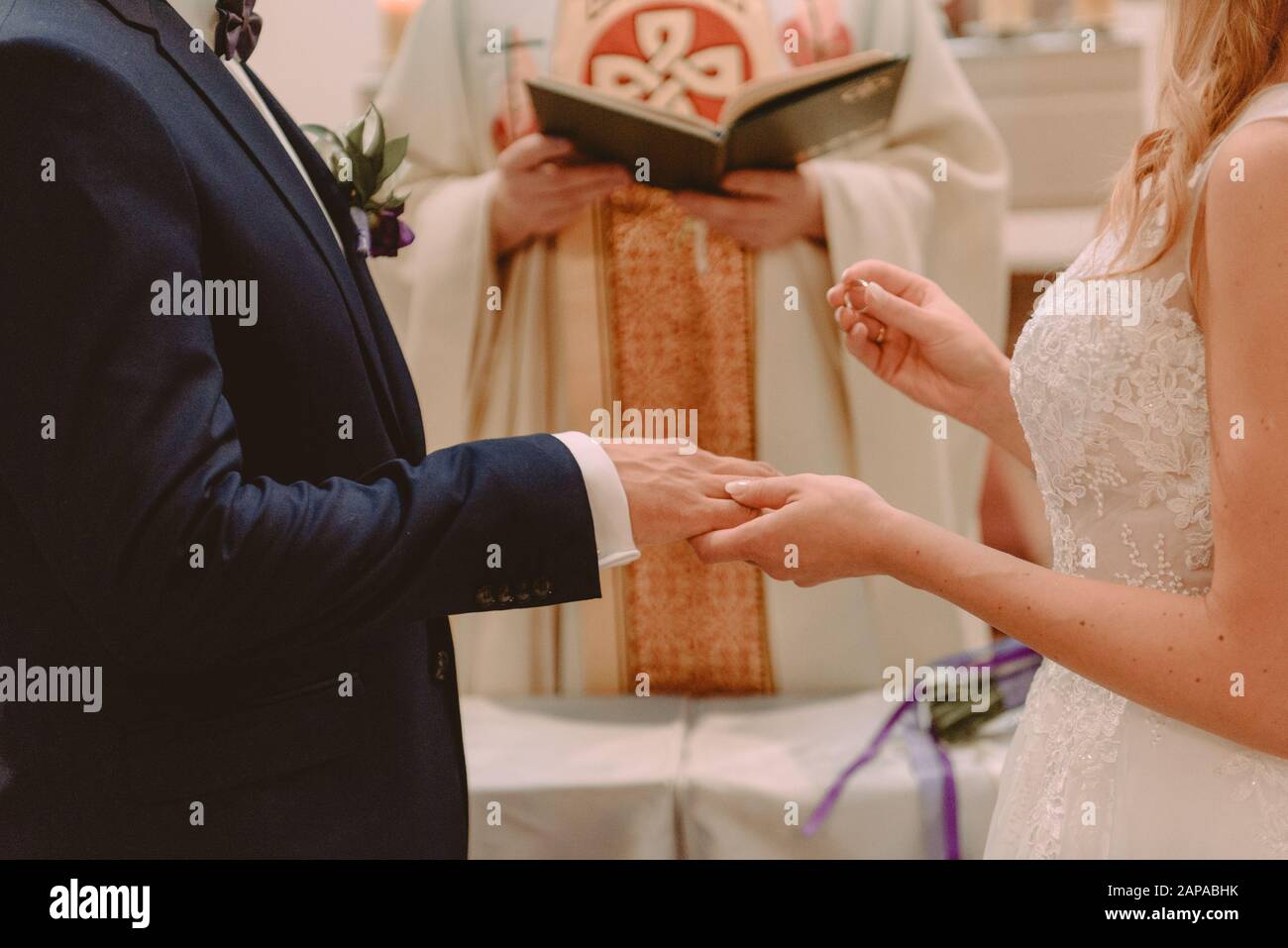 La sposa e lo sposo durante la cerimonia di nozze mettere gli anelli di nozze sulla loro dita. Foto Stock