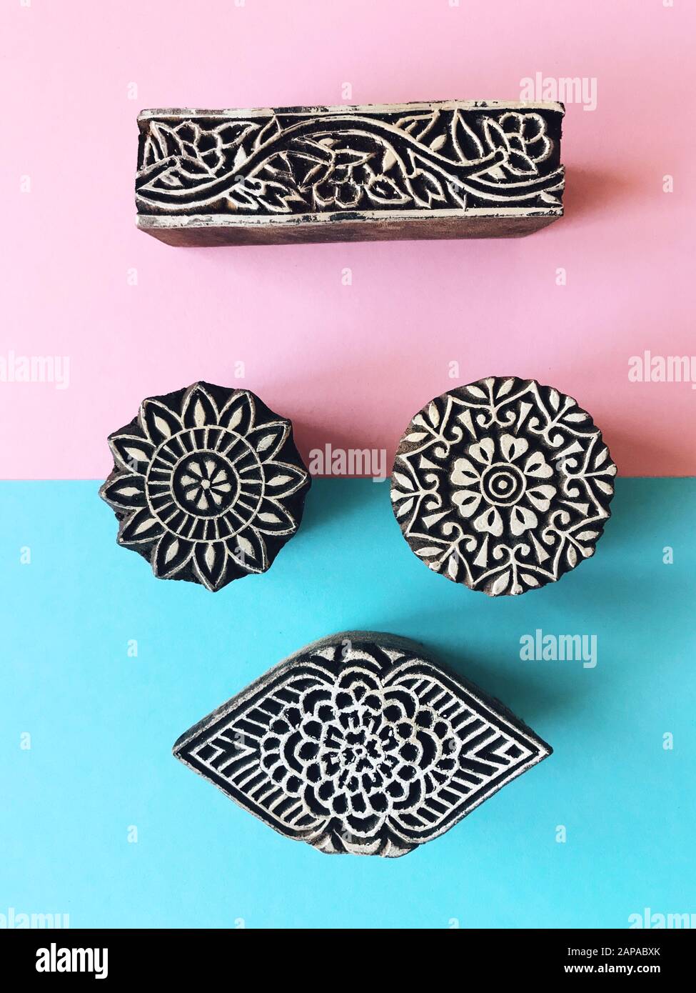 Creative Flat Lay kalamkari francobolli in legno su sfondo color pastello. Carta di colore pastello blu e rosa sfondo geometrico piatto con kalam indiano Foto Stock