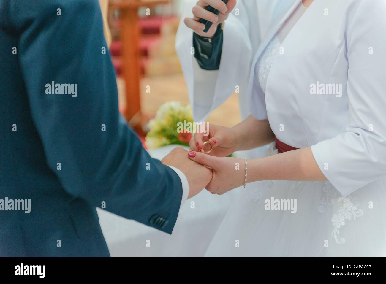 La sposa e lo sposo durante la cerimonia di nozze mettere gli anelli di nozze sulla loro dita. Foto Stock