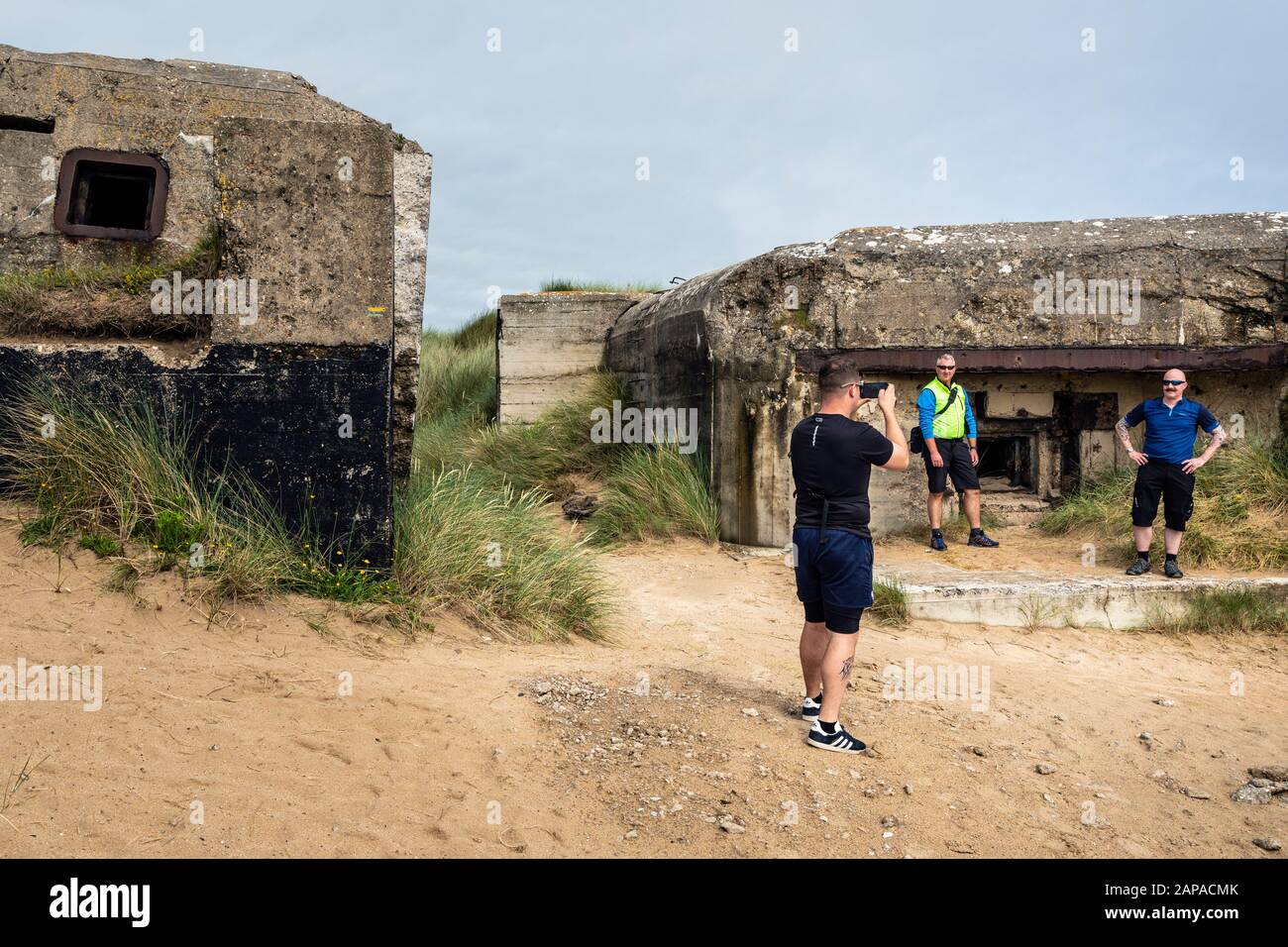 I turisti che scattano foto da un vecchio bunker tedesco della seconda guerra mondiale a Utah Beach, Normandia, Francia Foto Stock