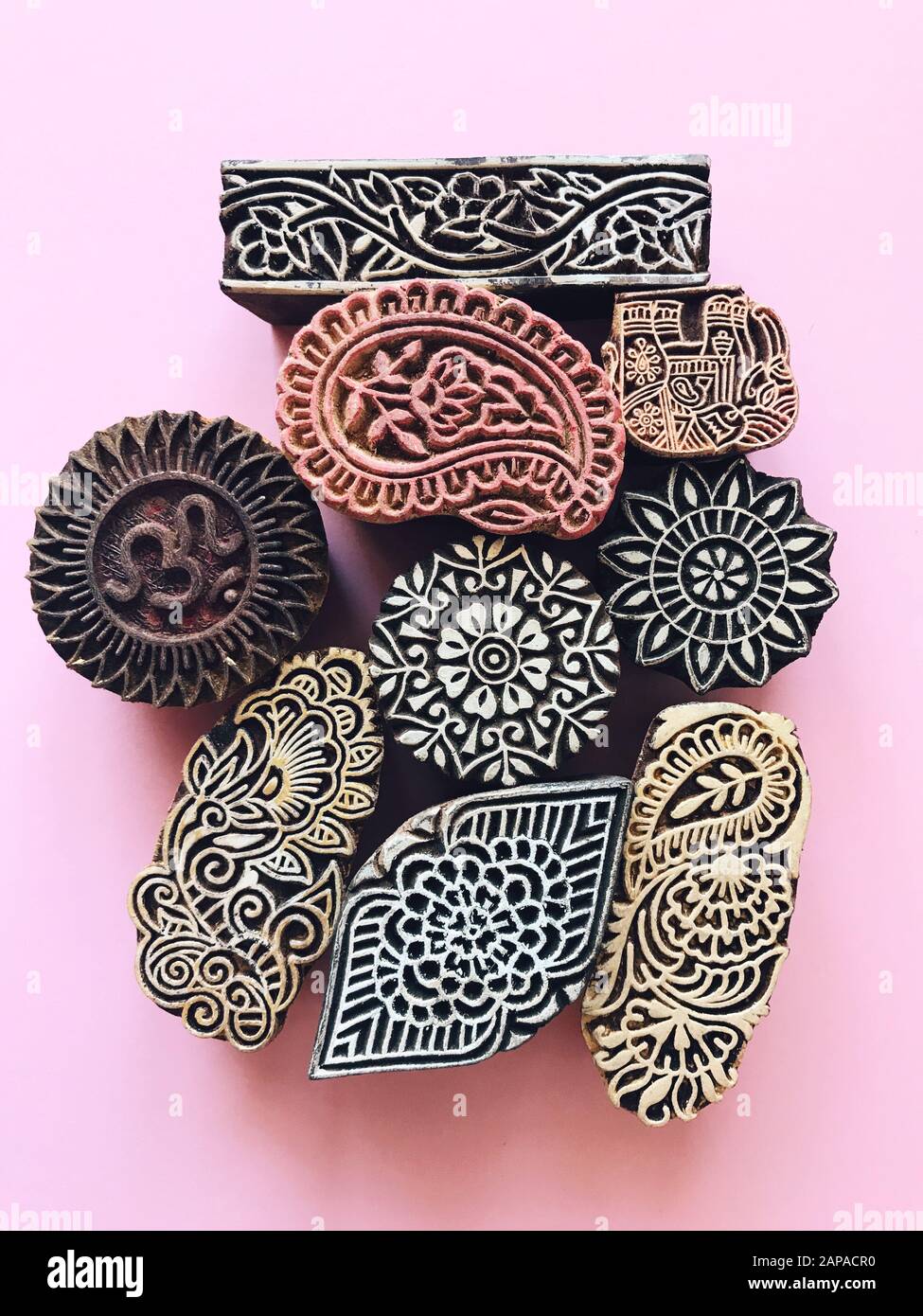Creative Flat Lay kalamkari francobolli in legno su sfondo color pastello. Carta di colore pastello rosa sfondo geometrico piatto con kalamkari indiano sta Foto Stock