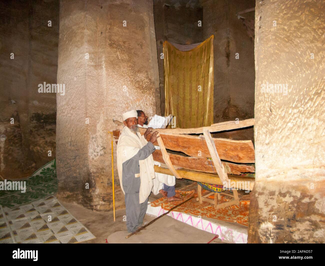 Il sacerdote della chiesa scavata nella roccia di Medhane Alem Adi Kasho legge la sua bibbia, Teka Tesfai, Tigray, Etiopia. Foto Stock