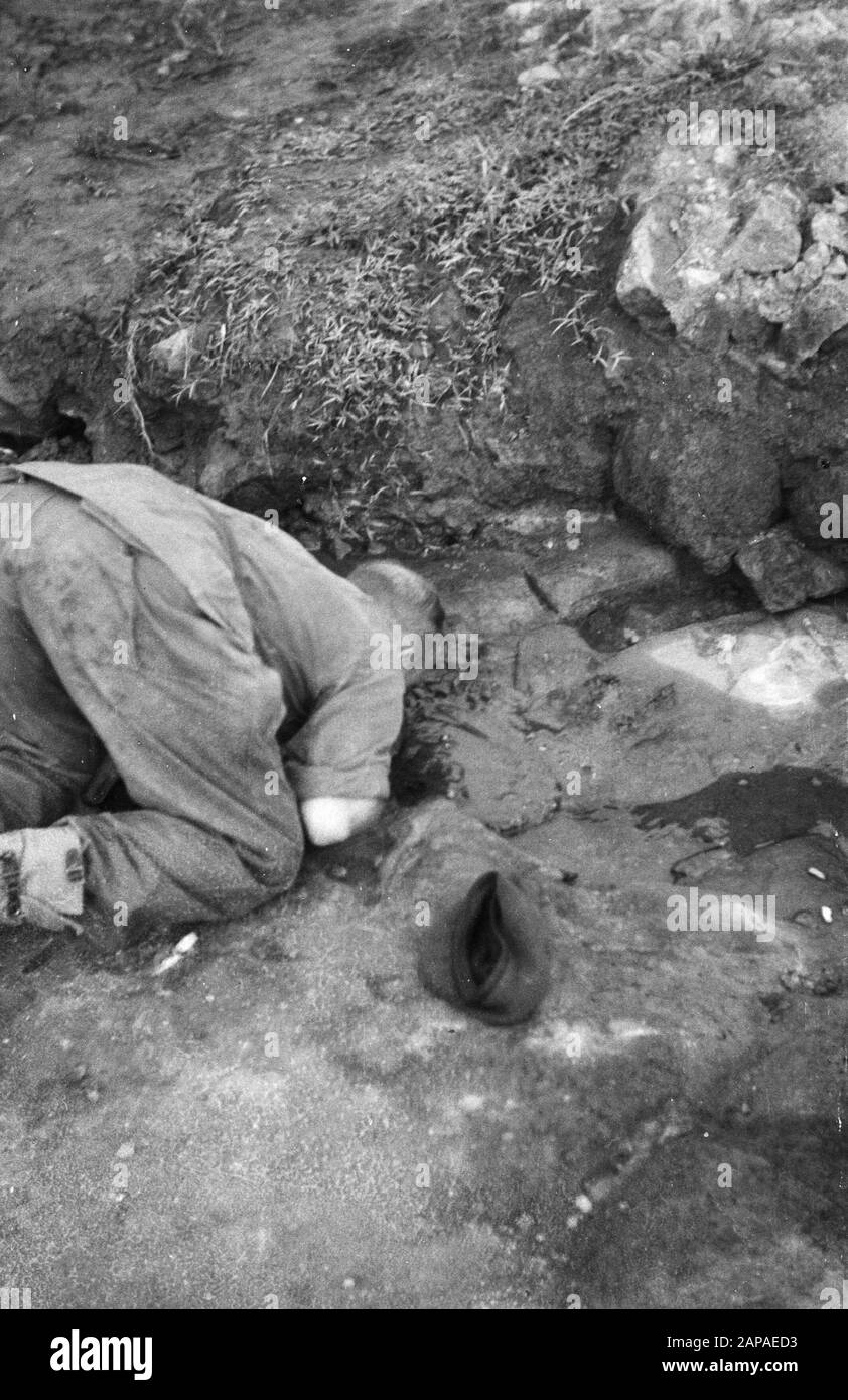 Gading e Plajen, azione per terreno montano Descrizione: Azione in direzione di Gading, Plajen e Wonosari. La fanteria marciò di notte per chiudere la zona dove le bande erano state segnalate quando la pulizia è iniziata al mattino. Militare al di sopra di un buco nel suolo di roccia Data: 9 marzo 1949 luogo: Indonesia, Java, Indie orientali olandesi Foto Stock