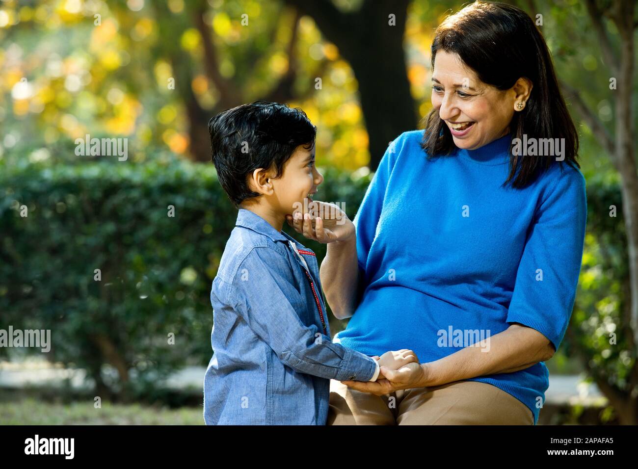 Nonna amorevole che gioca con suo nipote al parco Foto Stock