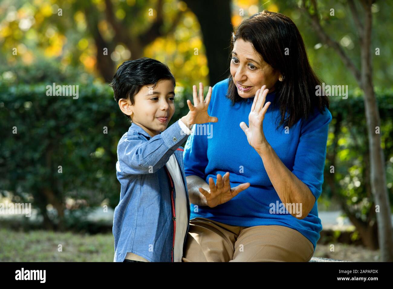 Nonna amorevole che gioca con suo nipote al parco Foto Stock