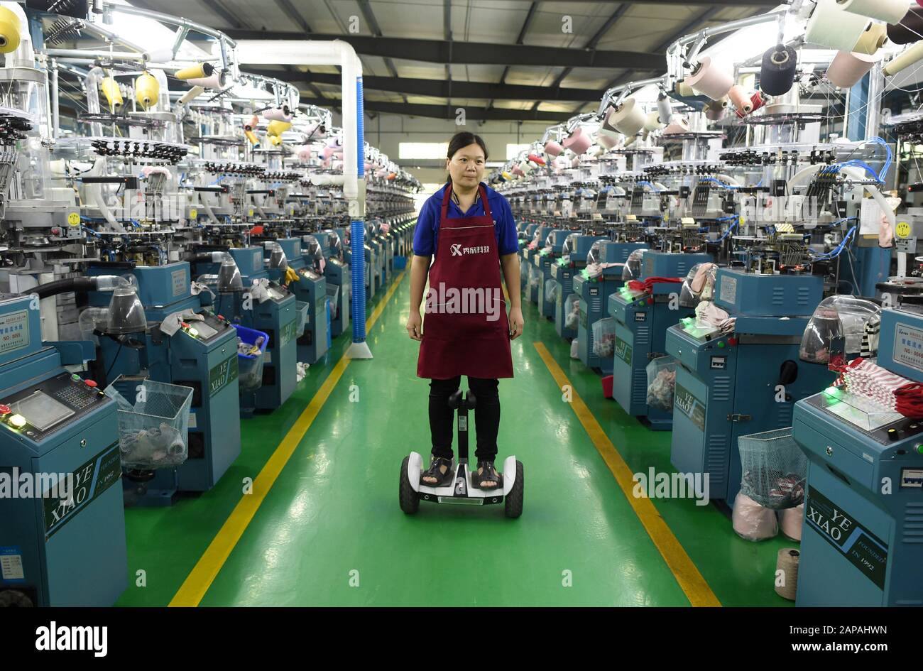 (200122) -- HANGZHOU, 22 gennaio 2020 (Xinhua) -- UN lavoratore ispeziona le macchine in un laboratorio intelligente di una azienda di calzetteria a Zhuji, nella provincia di Zhejiang della Cina orientale, 23 ottobre 2019. Per ANDARE CON 'Xinhua in primo piano: La potenza economica guida la legislazione nel beefing up settore privato' (Xinhua/Han Chuanhao) Foto Stock