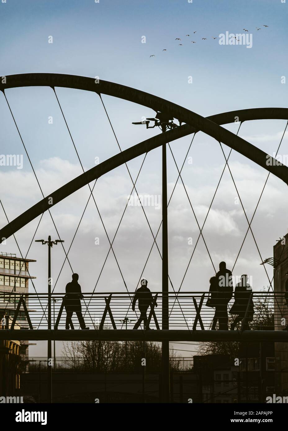 Il Manchester Curve Bridge a Piccadilly Place a Manchester, pieno di pendolari e pedoni Foto Stock