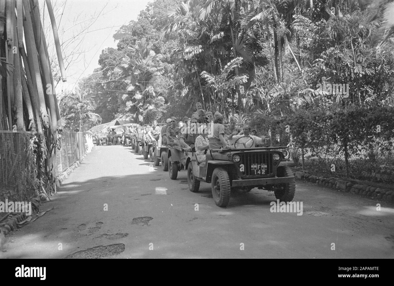 Fotografie aeree e di cura all'aperto Descrizione: Cure all'aperto. Il giardino botanico 's-Land' di Buitenzorg offre ai soldati feriti, che sono già sul mend, una vacanza selezionata e resort ricreativo. Sotto la guida del Prof. Boss Becking, direttore di questo famoso istituto, fanno un giro del terreno dove la ricchezza della fauna e della flora indiane è unita in una deliziosa annotazione intera: Nel fronte jeep (in camicia bianca) direttore Prof. L.G.M. Baas Becking, Mentre Spiega Data: Agosto 1947 Località: Indonesia, Indie Orientali Olandesi Foto Stock
