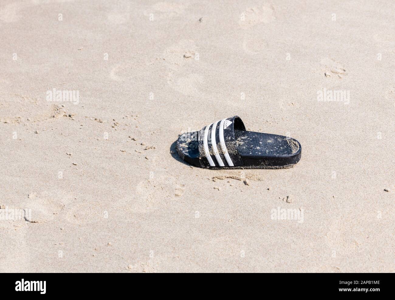 Flip flop/sandalo scartato sulla spiaggia Foto Stock