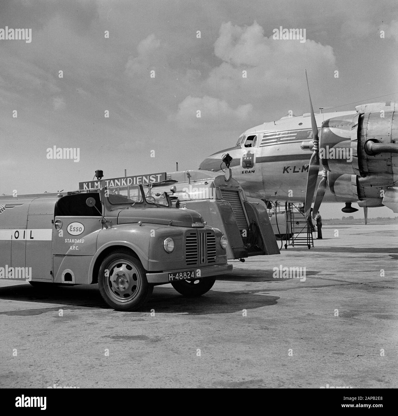 Stile aziendale ed emblemi KLM Descrizione: The Douglas DC-4 Edam con l'identità aziendale KLM e con il logo Edam sotto la finestra laterale dell'abitacolo all'aeroporto di Schiphol al centro di partenza e autocisterne. Data: Agosto 1951 luogo: Noord-Holland, Schiphol Parole Chiave: Emblemi, loghi, carri cisterna, aerei Foto Stock