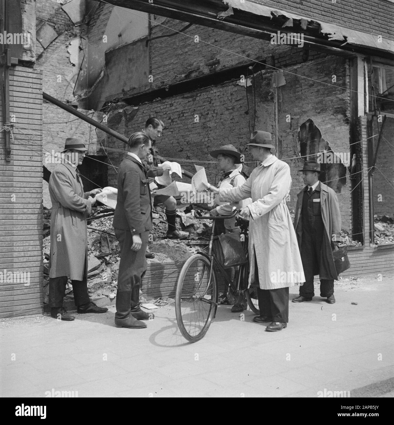 Recupero: Arnhem Descrizione: Il giornale cattolico Arnhems Dagblad è distribuito a lavoratori e cittadini. Tra di loro un uomo in ragazzo scout uniforme Data: 1945 luogo: Arnhem, Gelderland Parole Chiave: Recupero, seconda guerra mondiale, ricostruzione Foto Stock