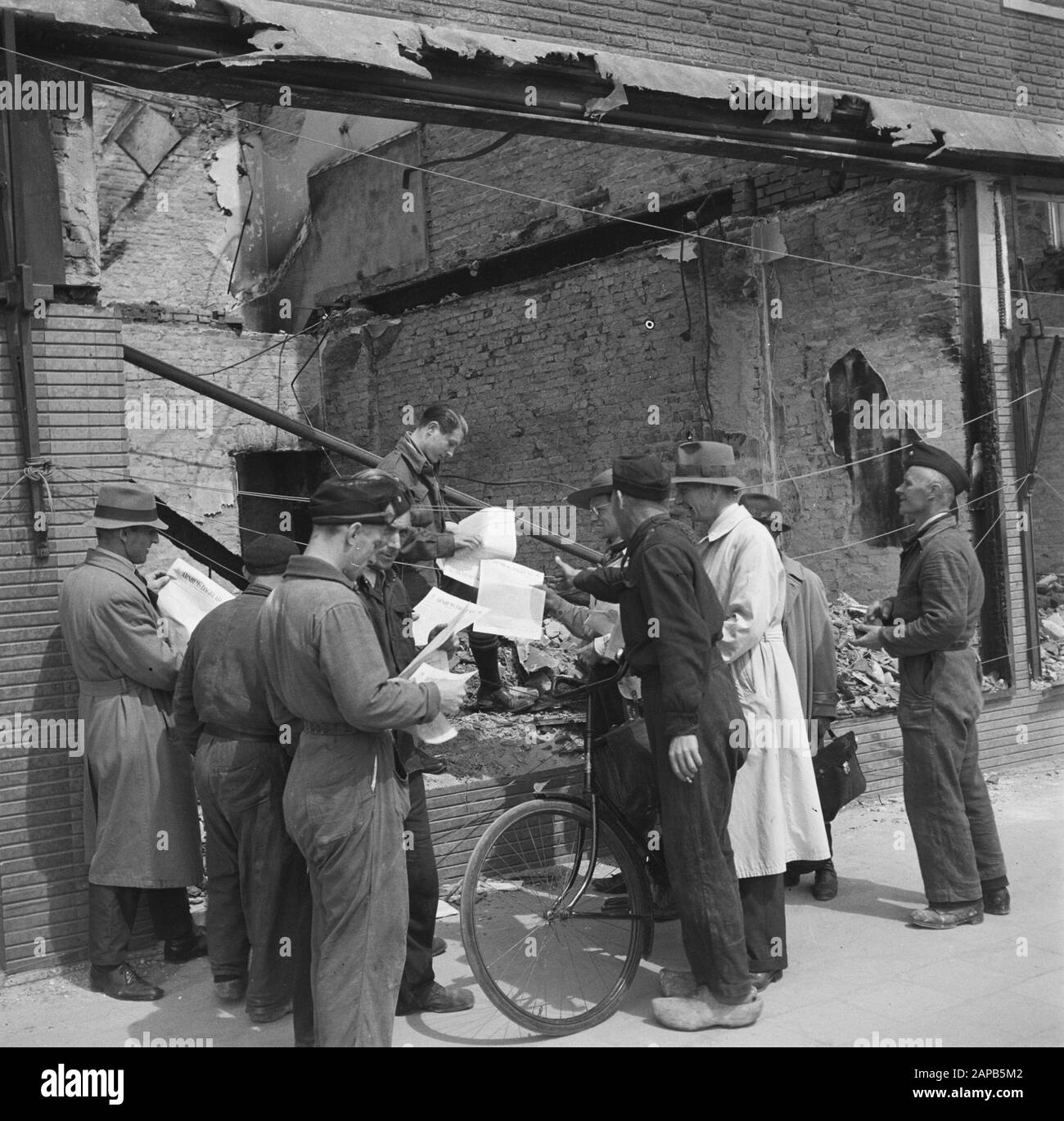 Recupero: Arnhem Descrizione: Il giornale cattolico Arnhems Dagblad è distribuito a lavoratori e cittadini. Tra di loro un uomo in ragazzo scout uniforme Data: 1945 luogo: Arnhem, Gelderland Parole Chiave: Recupero, seconda guerra mondiale, ricostruzione Foto Stock