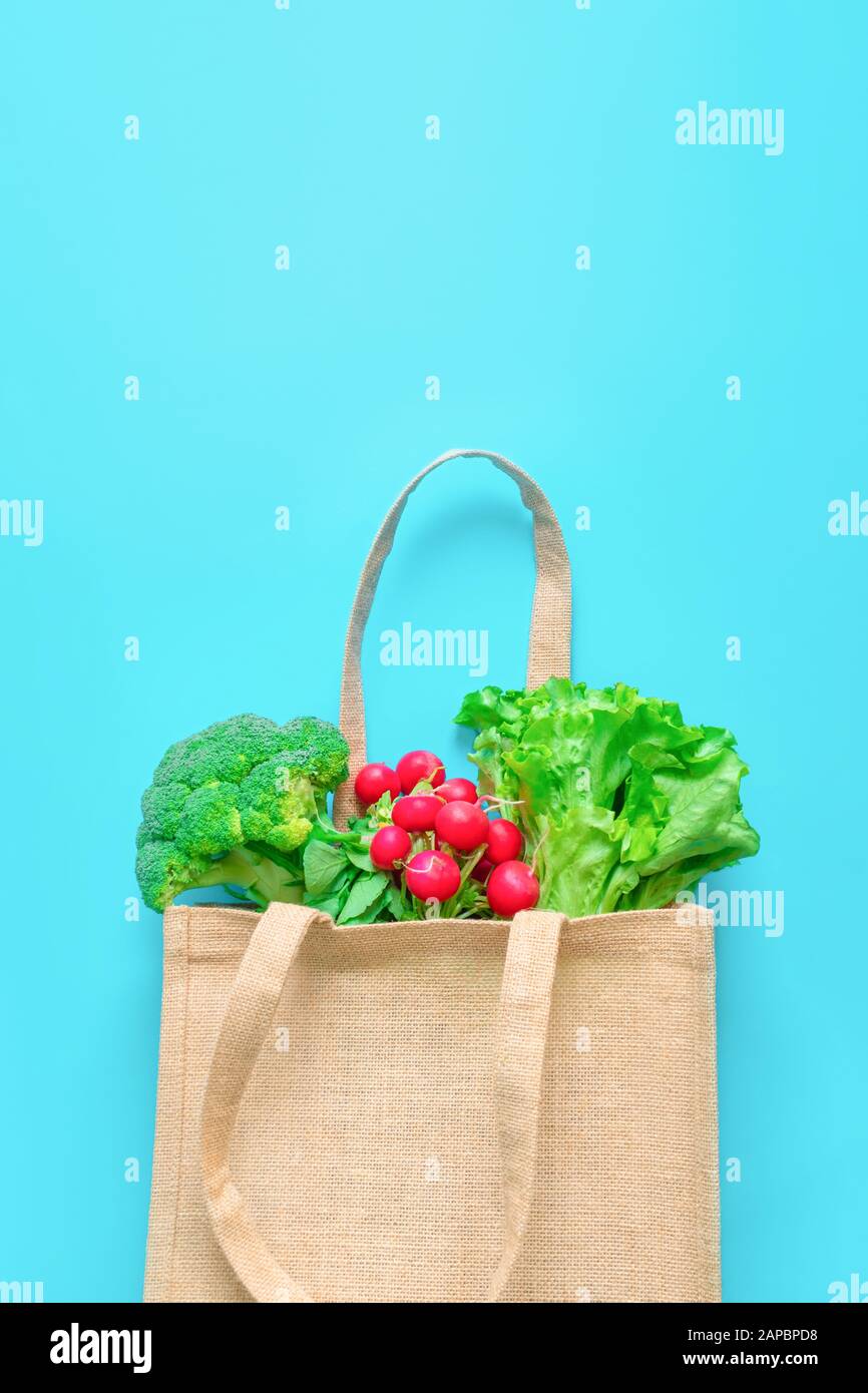 Verdure fresche in sacchetto di tessuto riutilizzabile su fondo blu. Foto Stock