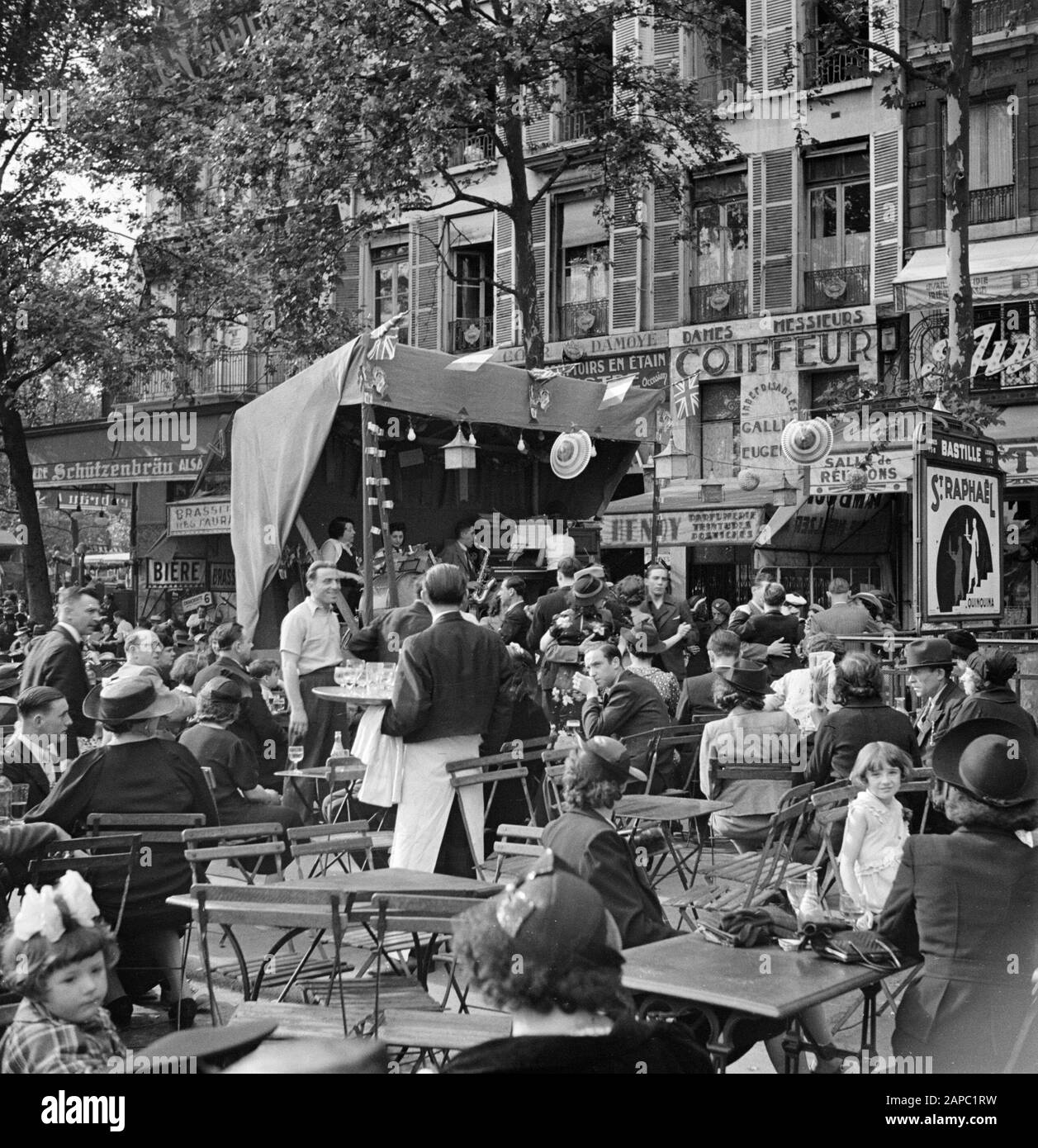 Quatorze Juillet a Parigi Descrizione: 14 luglio 1938 Parigi, festa di persone a Place de la Bastille. Terrazza con camerieri e orchestra con 3 donne e 1 uomo. Destra l'entrata della metropolitana Bastille con la caratteristica pubblicità di San Raphaël Data: 14 luglio 1938 posizione: Francia, Parigi Parole Chiave: Popolazione, danze, feste, sottopavai, camerieri, sculture di strada, terrazze Nome personale: Bastille Foto Stock