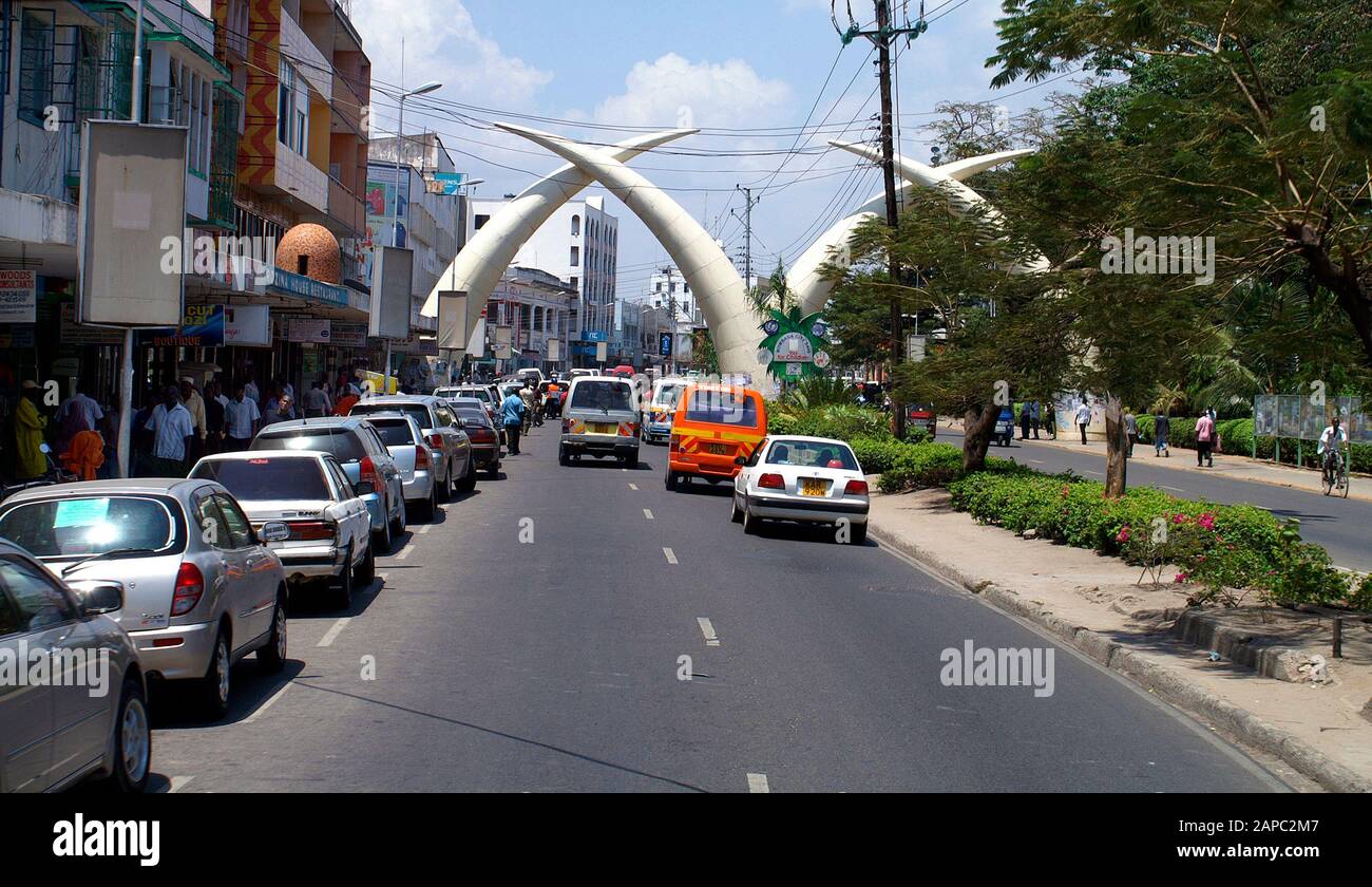 Mombasa, Kenya - 04 febbraio 2011: Persone non identificate e braci d'avorio gigante - il punto di riferimento della città nella trafficata via Ivory-Avenue di Mombasa, A. Foto Stock