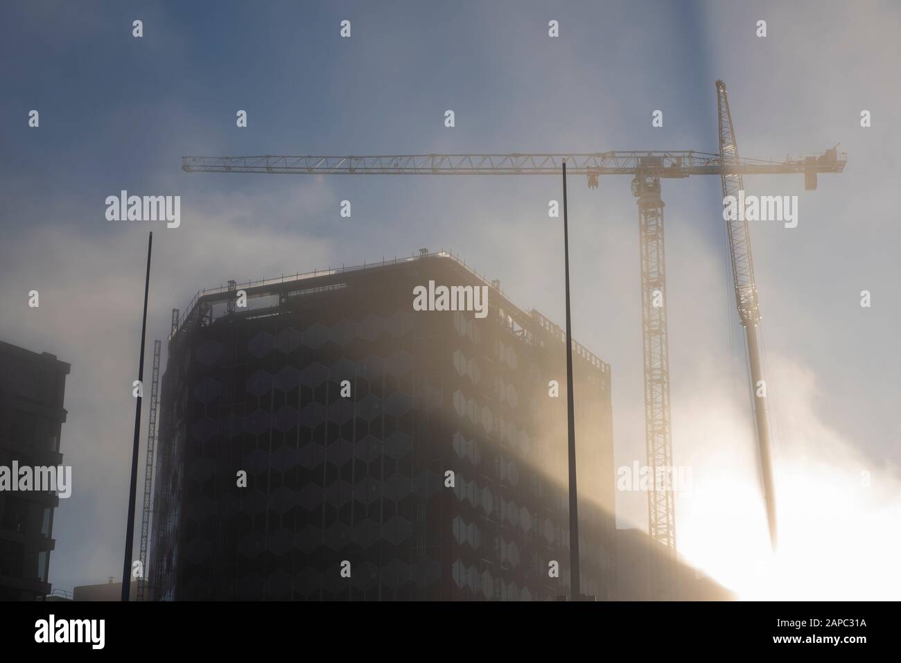 Taglio leggero attraverso la nebbia durante la costruzione di un nuovo edificio in Centenary Square Birmingham, West Midlands Inghilterra UK Foto Stock