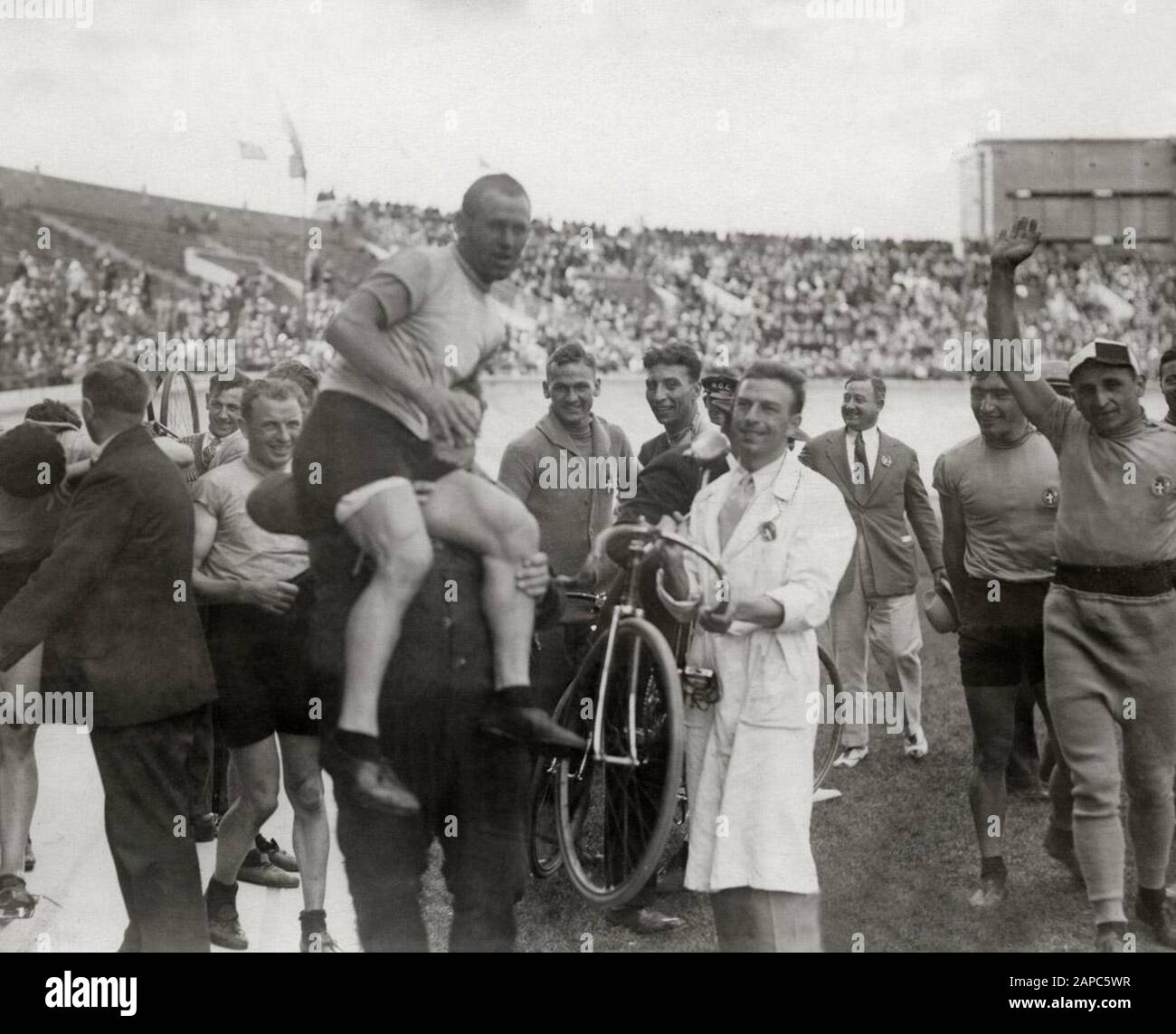 Spaarnestad Photo/SFA022000587 allietando ciclisti e accompagnatori italiani dopo aver vinto la medaglia d'oro nel 4000 metri di inseguimento durante le Olimpiadi di Amsterdam del 1928. Italiano: La compagine italiana di ciclismo su pista, vincitrice della medaglia d'oro nell'insedimento a squadre, durante i Giochi della IX Olimpiade; Foto Stock