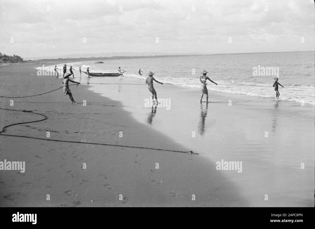 Pesca sul Mare dei Bambini vicino Tjilatjap Descrizione: Sulla spiaggia di Tjilatjap, la pesca viene effettuata con l'aiuto di reti da traino, che vengono portate in mare da calli. Poi tirato sulla spiaggia. Data: 1 Aprile 1948 Località: Cilacap, Indonesia, Indie Orientali Olandesi Foto Stock