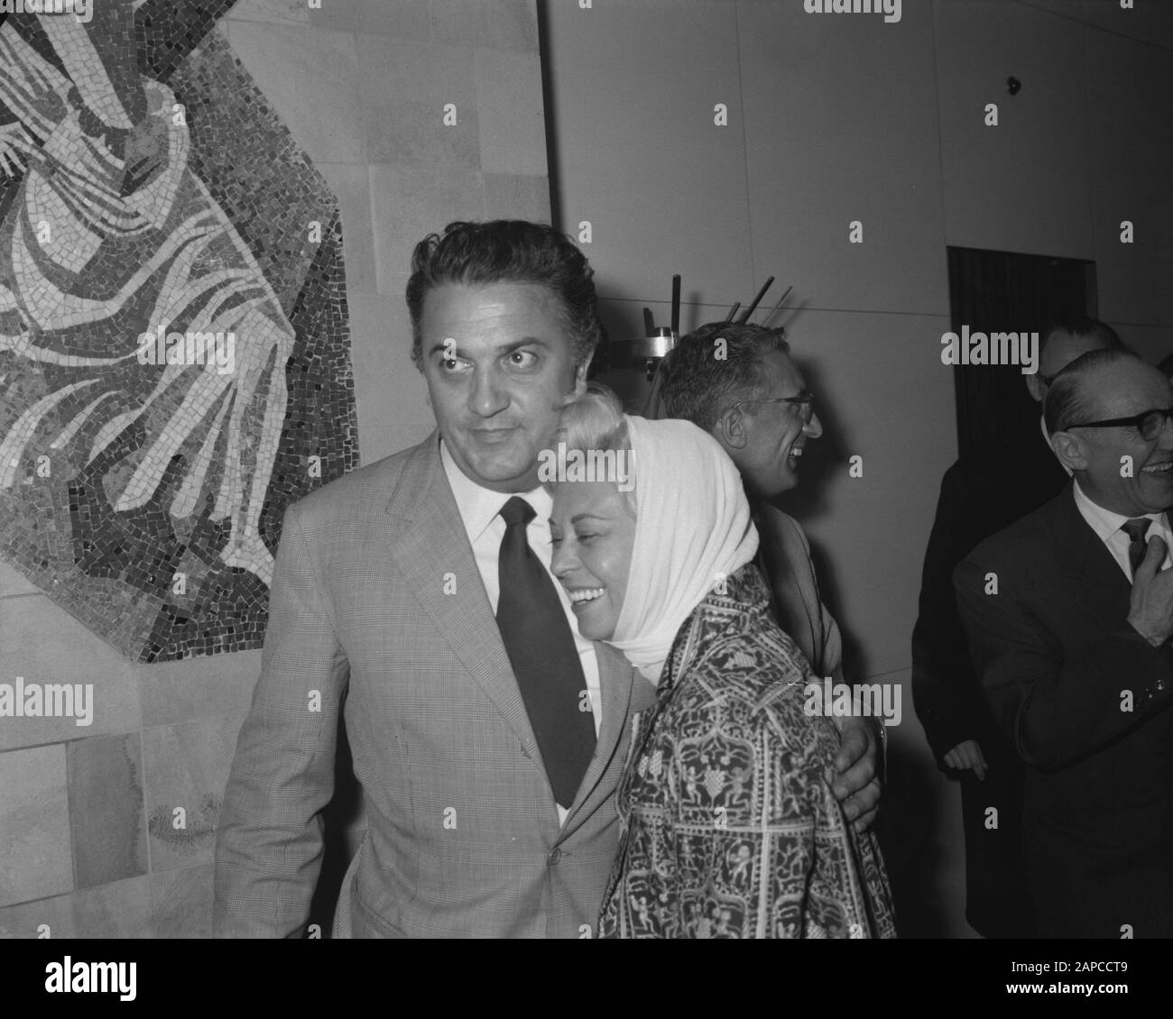 Arrivo il regista italiano Federico Fellini e sua moglie l'attrice Giulietta Masina all'aeroporto di Schiphol. Durante la conferenza stampa Data: 9 giugno 1960 luogo: Noord-Holland, Schiphol Parole Chiave: Arrivi, attrici, registi, star del cinema, conferenze stampa Nome personale: Fellini Federico, Masina, Giullieta Foto Stock
