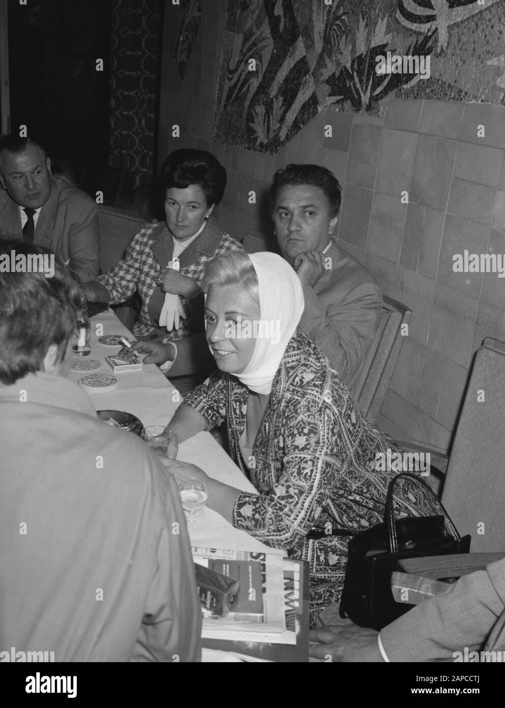 Arrivo il regista italiano Federico Fellini e sua moglie l'attrice Giulietta Masina all'aeroporto di Schiphol. Durante la conferenza stampa Data: 9 giugno 1960 luogo: Noord-Holland, Schiphol Parole Chiave: Arrivi, attrici, registi, star del cinema, conferenze stampa Nome personale: Fellini Federico, Masina, Giullieta Foto Stock