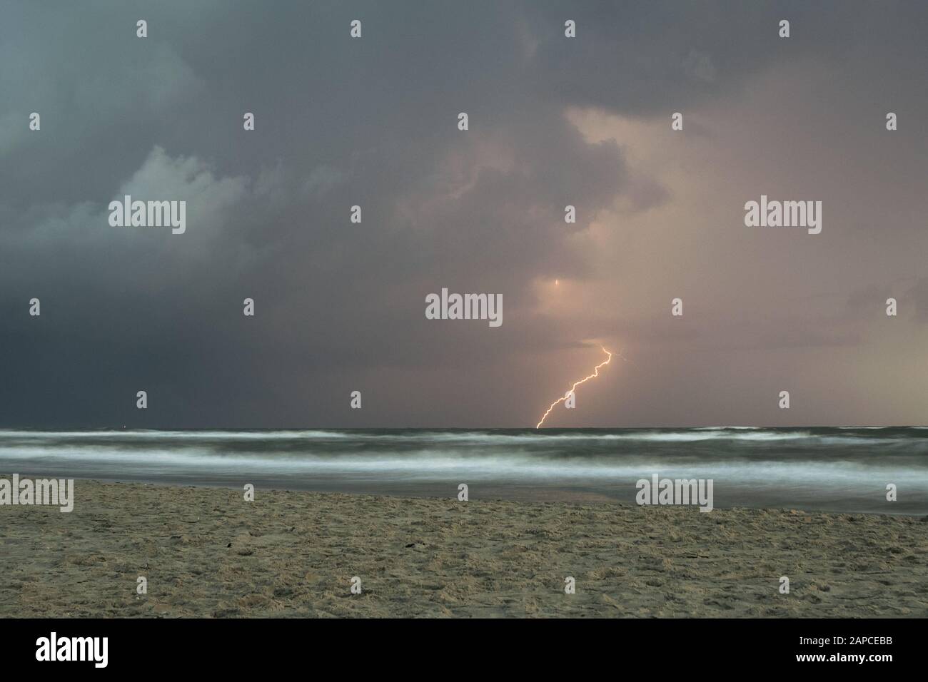 Fulmine colpisce in acqua da una tempesta sul mare Foto Stock