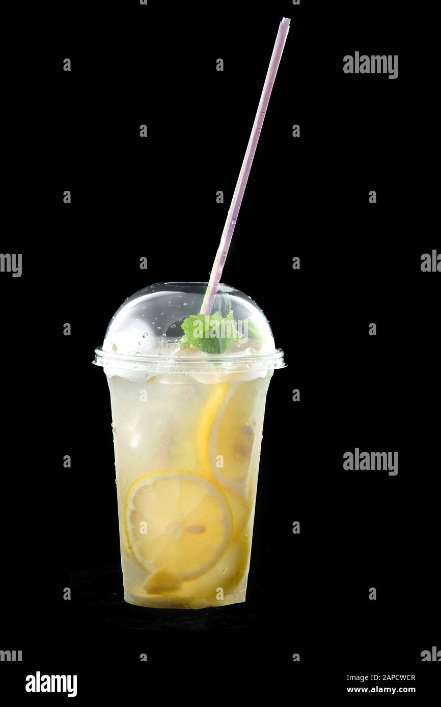 Bibita fresca dissetante limonata o cocktail mojito con limone e menta. C'è una paglia da bere nel bicchiere. Isolato su sfondo nero. Foto Stock