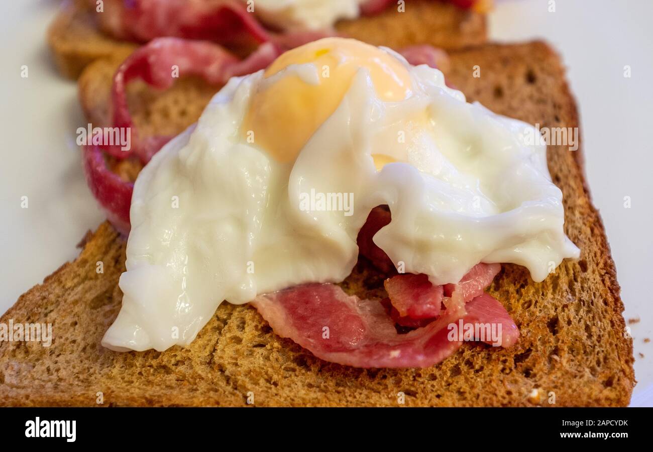 Uova in camicia, pancetta e toast Foto Stock