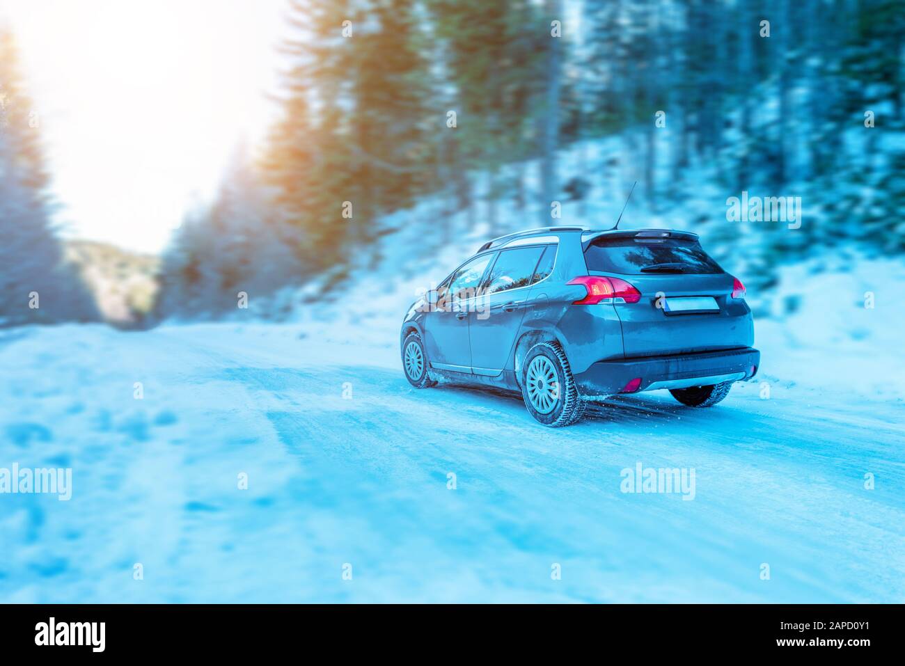 Guida di un'auto in inverno attraverso una strada di montagna. Concetto di vacanza invernale con attrezzature di sicurezza Foto Stock