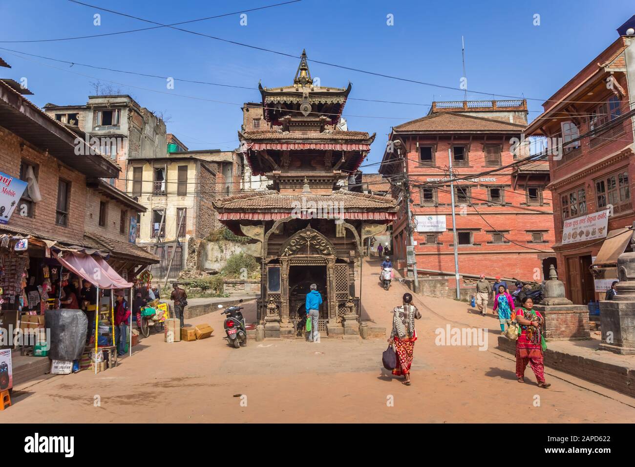 Piccolo tempio e negozi in una strada polverosa a Bhaktapur, Nepal Foto Stock
